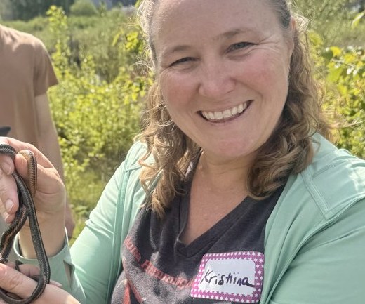 Kristiina Hurme holding a garter snake on a field trip